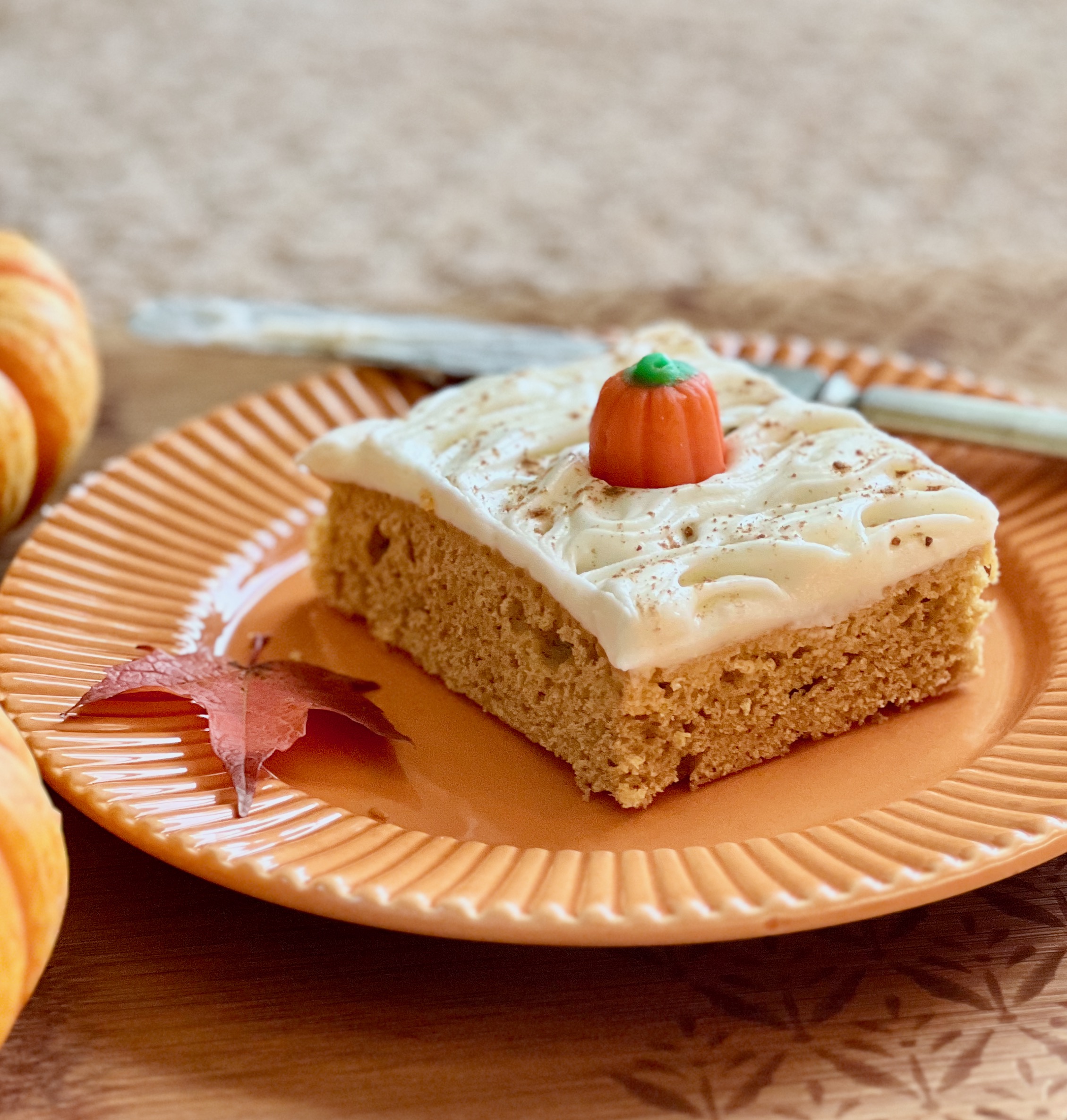 one pumpkin bar with maple cream cheese frosting on a plate
