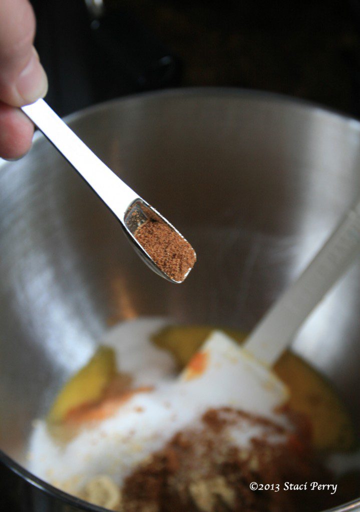 adding nutmeg to pumpkin pie filling in mixing bowl
