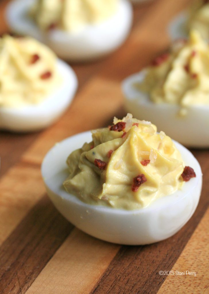 wood cutting board with deviled eggs on it