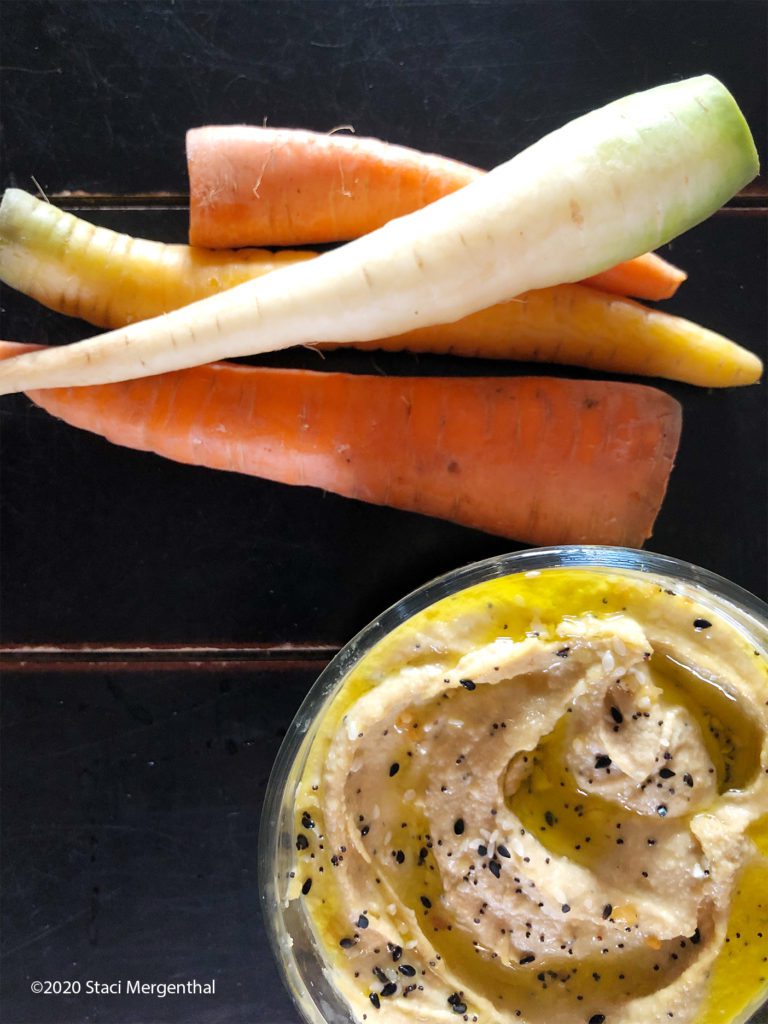 bowl of smoky garlic hummus and pile of fresh from the garden carrots