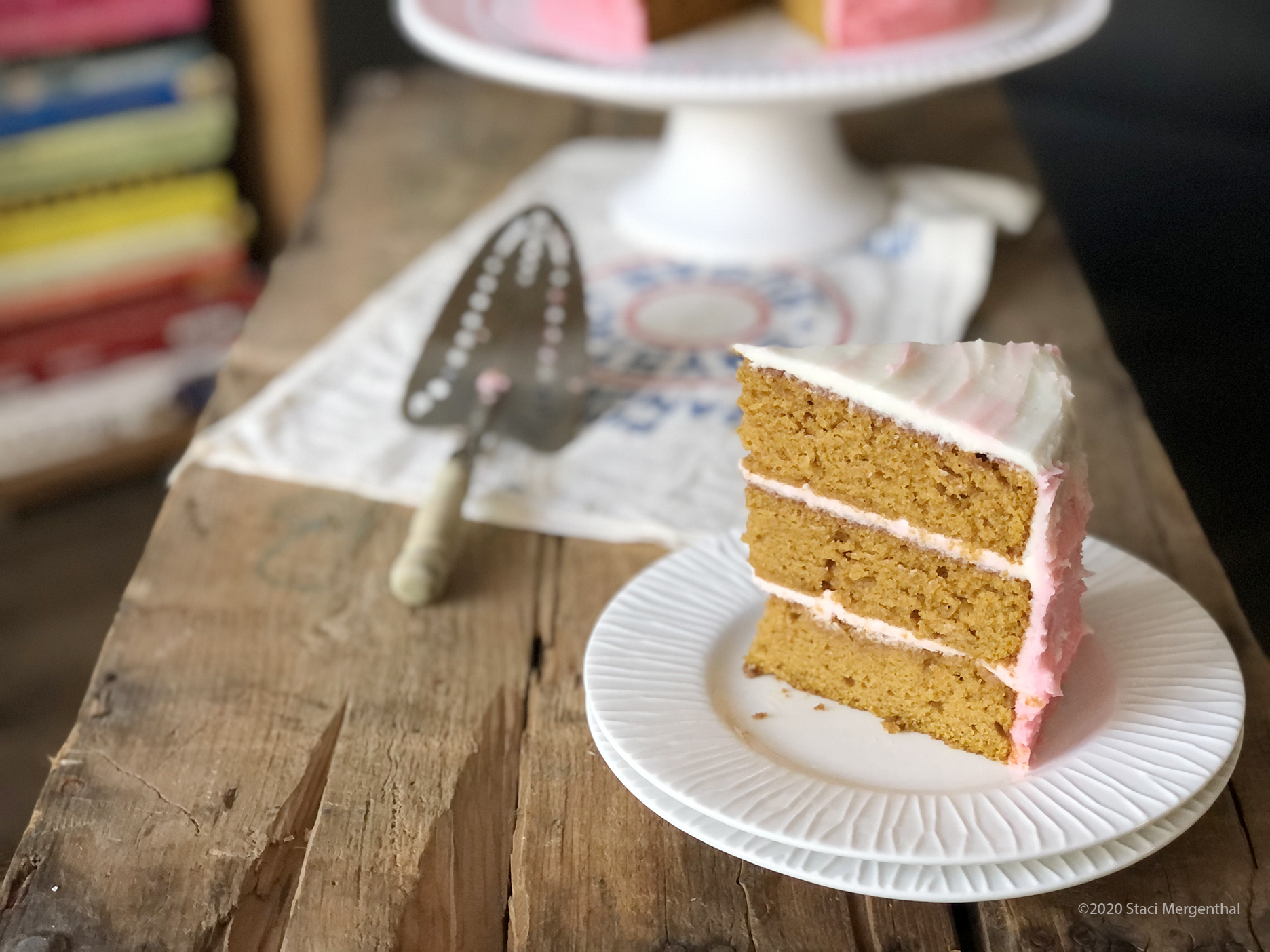slice of 3-layer pumpkin cake with maple buttercream frosting