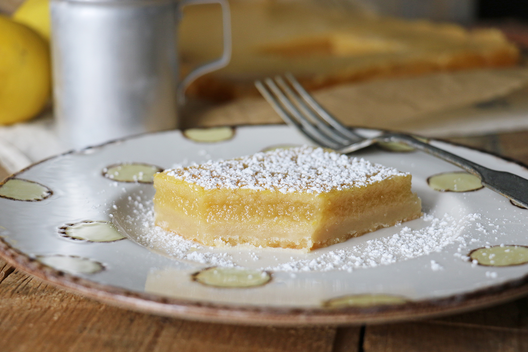 lemon bar on a plate with a fork