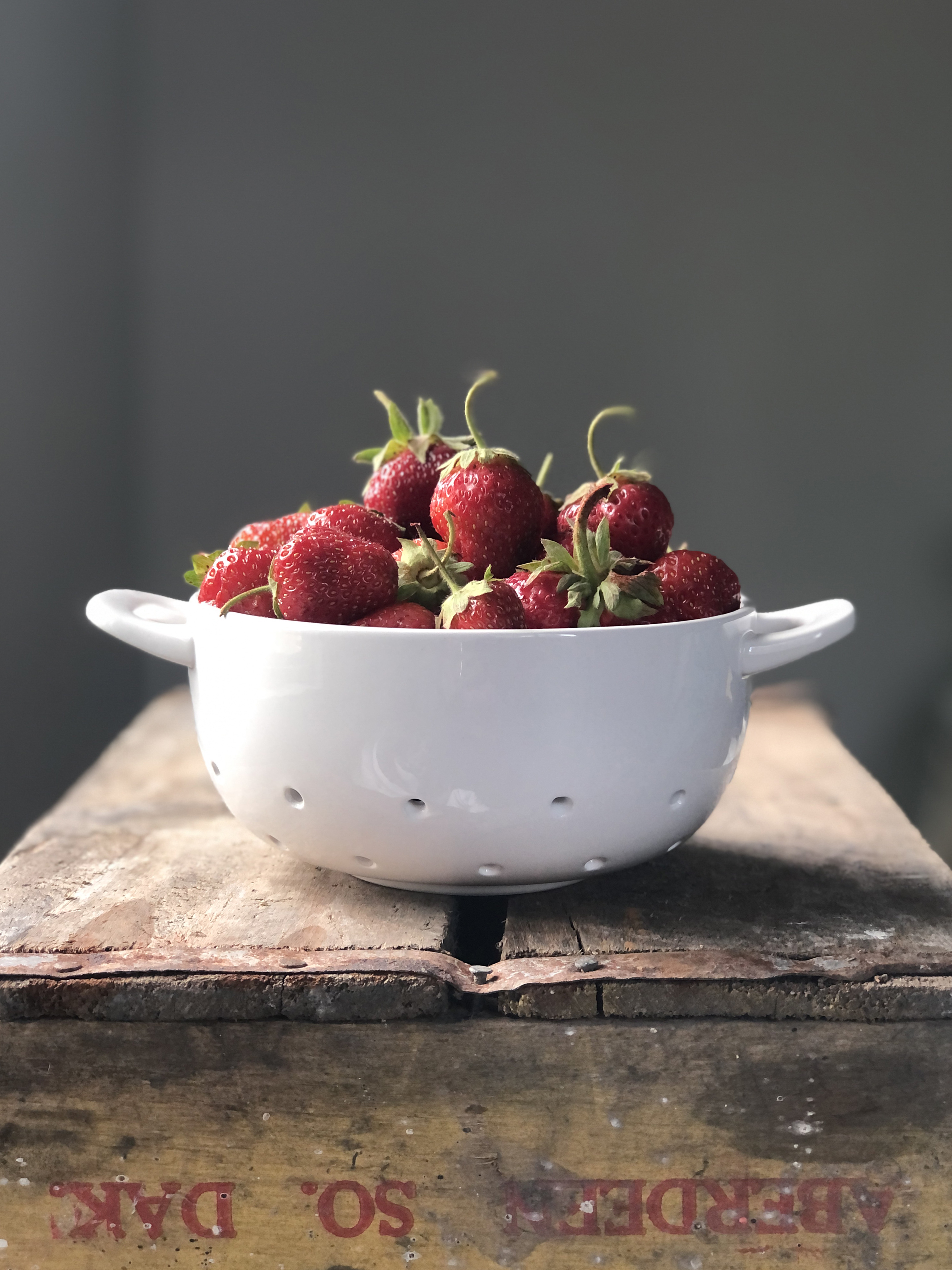 white ceramic strainer with strawberries