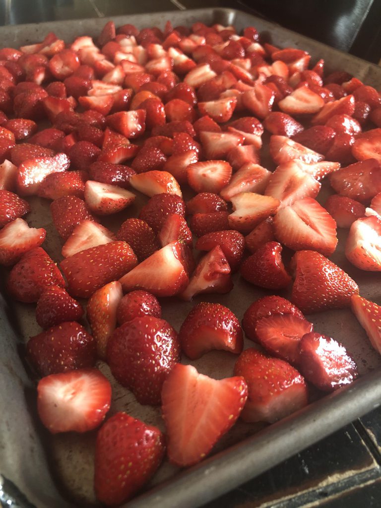 sliced strawberries on pan in single layer to freeze