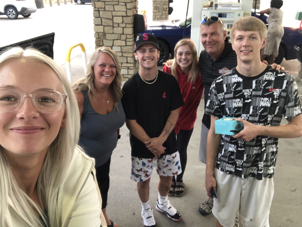 six people at the gas station pumps