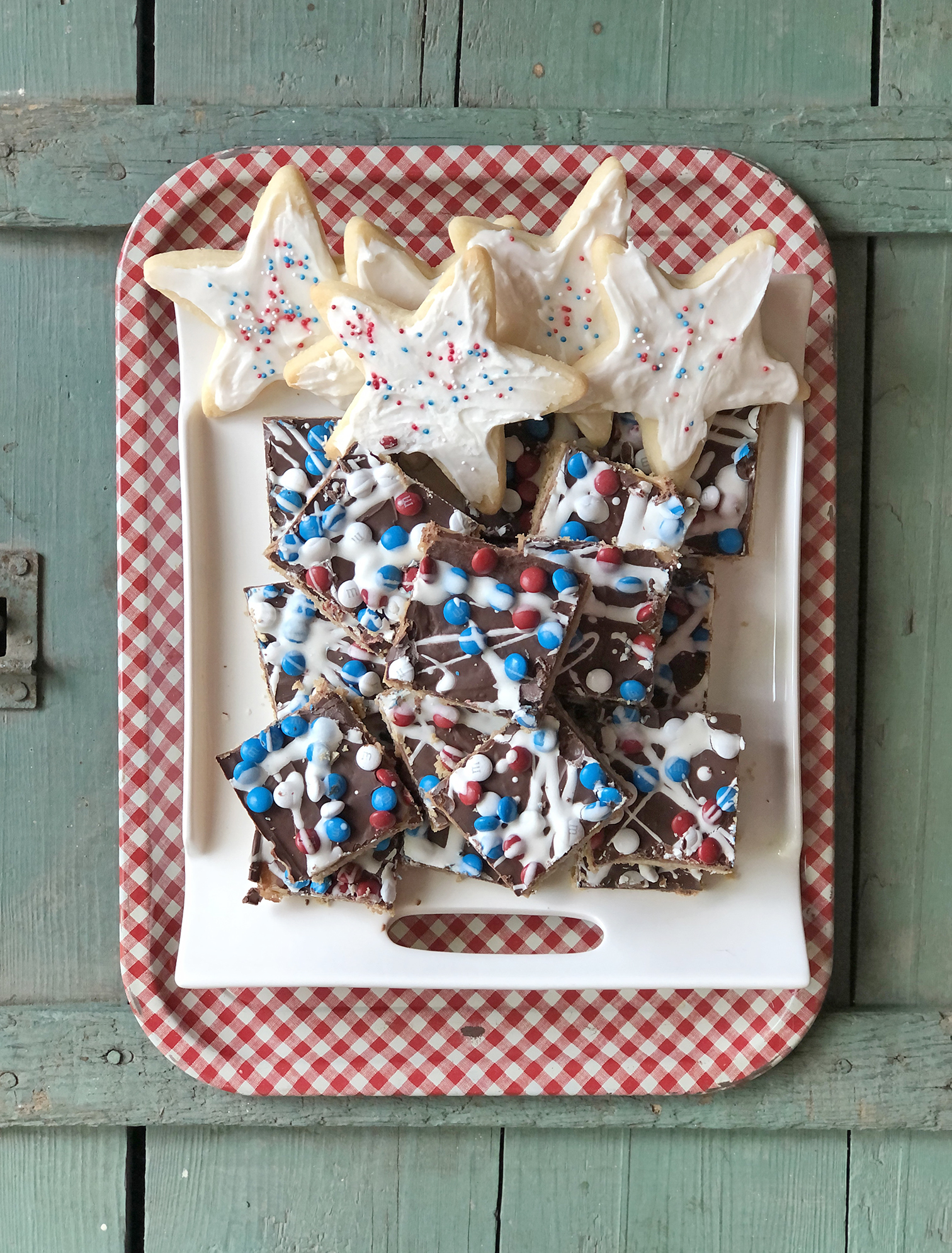 red white and blue caramel oatmeal bars and red white and blue star cookies on tray