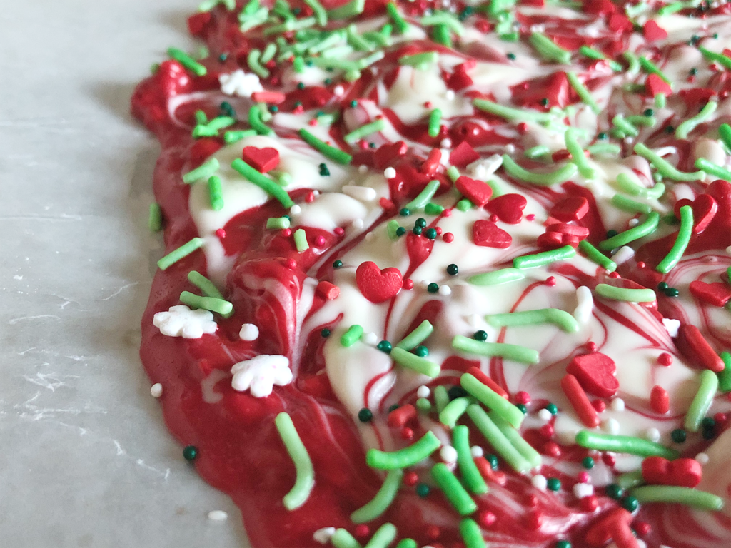Jolly Grinch Bark red and white almond bark with red white and green sprinkles 