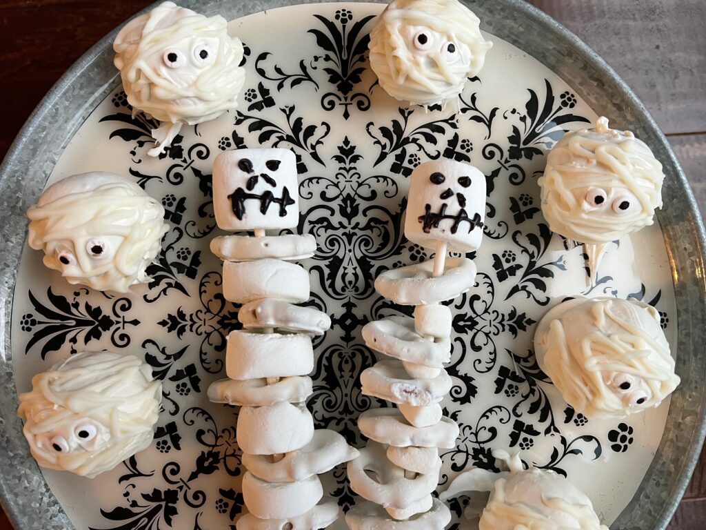 mummy cake balls and pretzel skeletons on cake stand