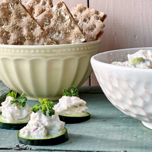 turkey salad on cucumbers with bowl of turkey salad and crisp bread