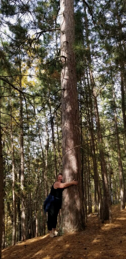 Staci hugging a tree at Neilson Spearhead Center