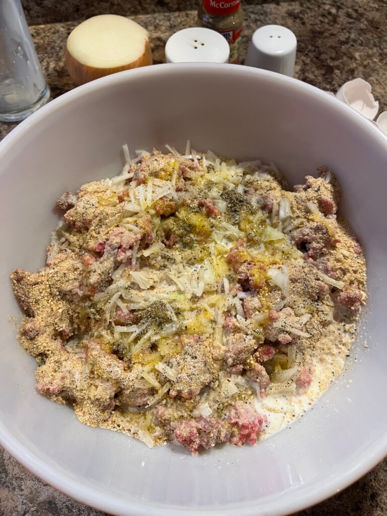 meatloaf mixture ready to mix with your hands in a bowl