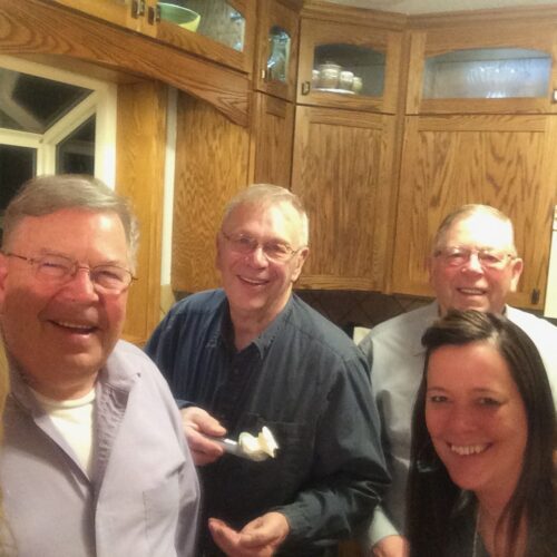 dad holding scoop of homemade ice cream with brothers and daughters