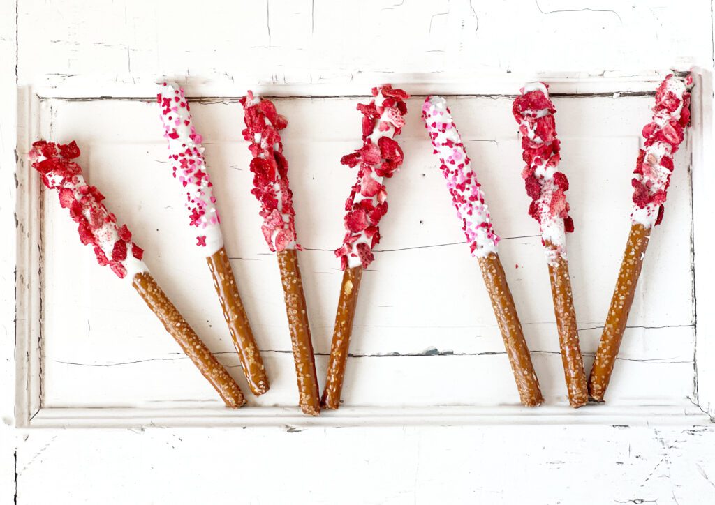 seven pretzel rods dipped in cream cheese flavored melts and freeze-dried strawberries