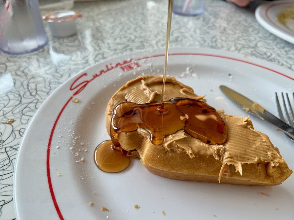 pouring maple syrup on a waffle at Sunliner Diner Gulf Shores
