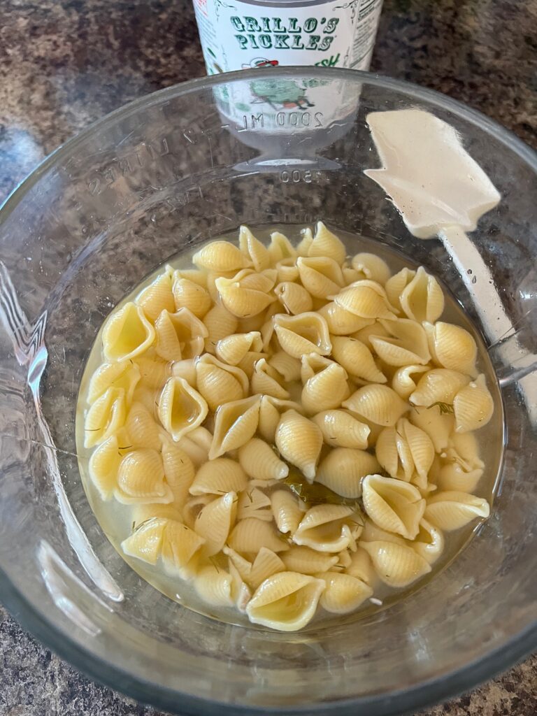 bowl of cooked pasta soaking in pickle juice