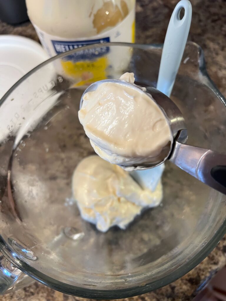 adding mayonnaise to a bowl 