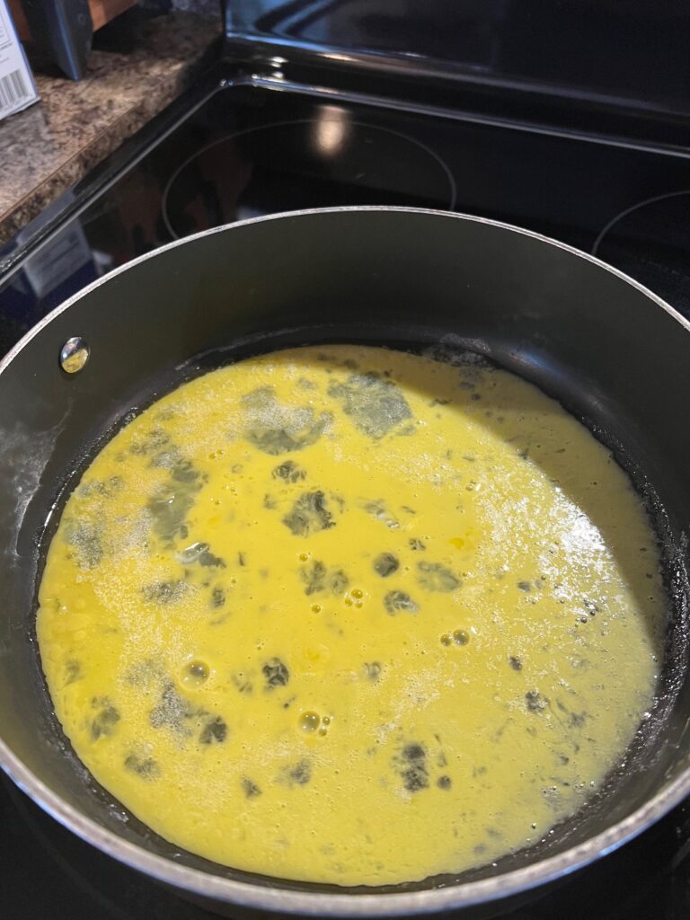 scrambled eggs cooking in a pan