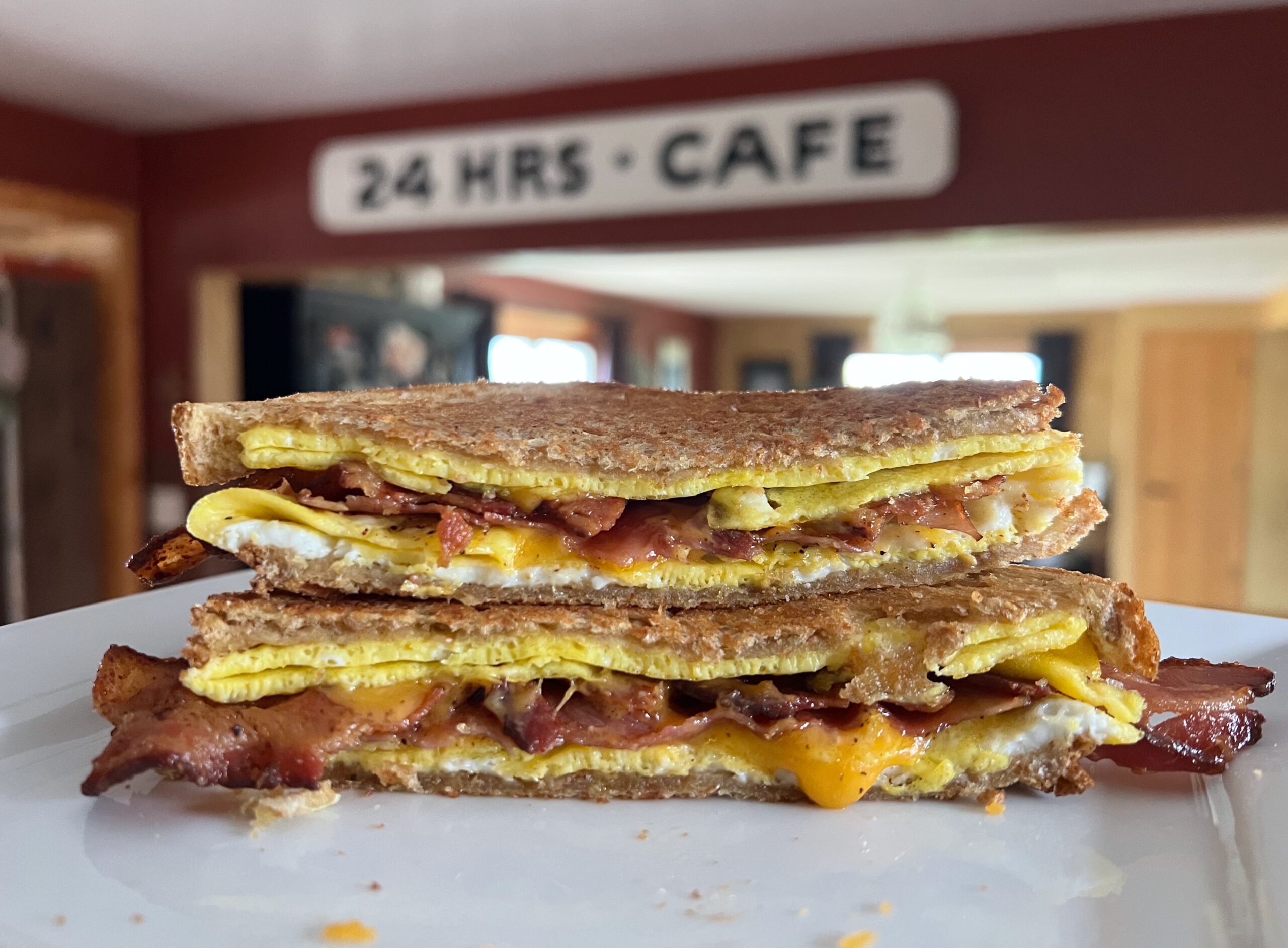 bacon ham egg and cheese breakfast sandwich on a plate