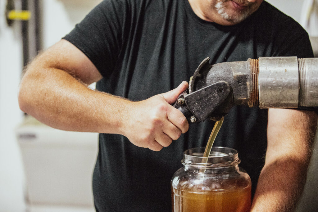 pouring honey into a jar