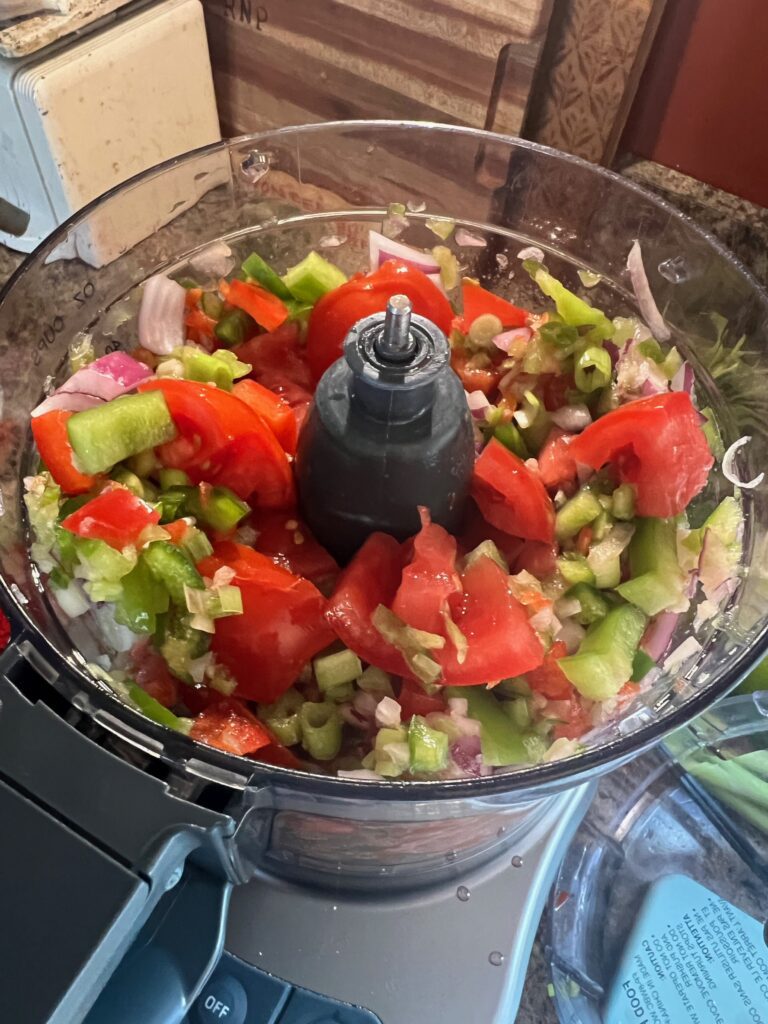 tomatoes and veggies in a food processor for salsa