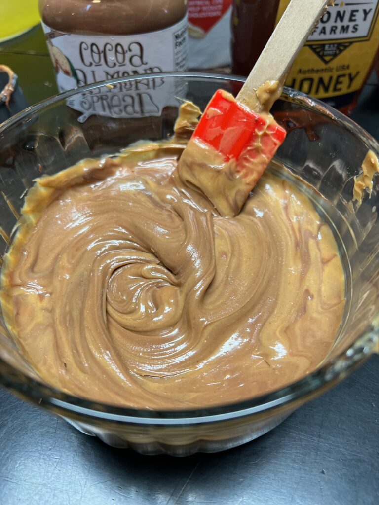 stirring peanut butter and cocoa almond spread tougher in a bowl
