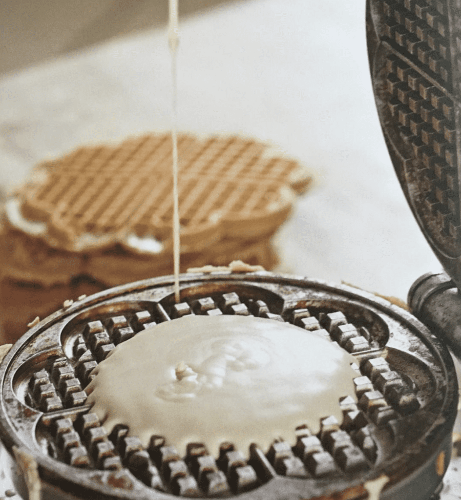 pouring waffle batter into a heart waffle iron