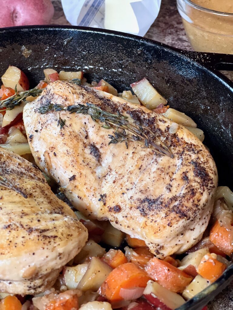 cast iron pan with roast chicken and vegetables