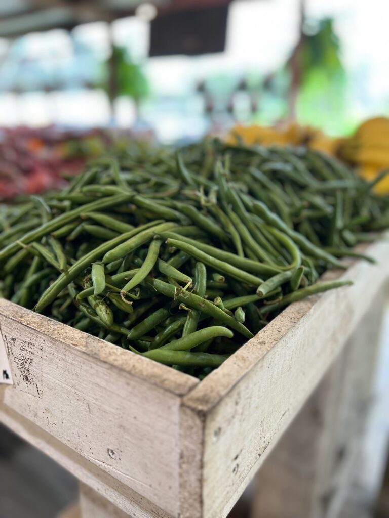 large bin of fresh green beans at farmers market