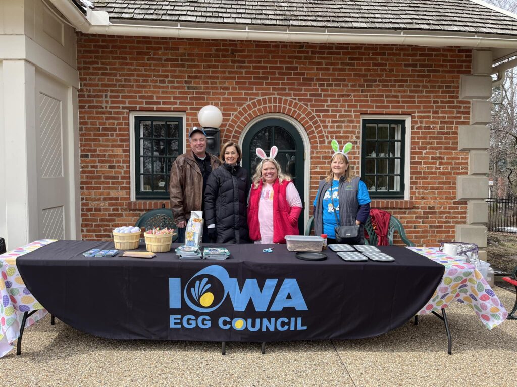 four people standing by Iowa Egg Council table