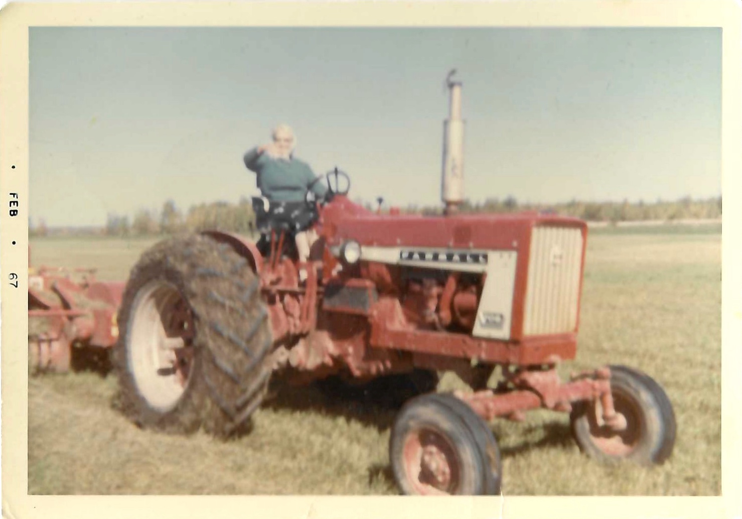 Great Grandma Emma Riemer on a red Farmall tractor in February 1967
