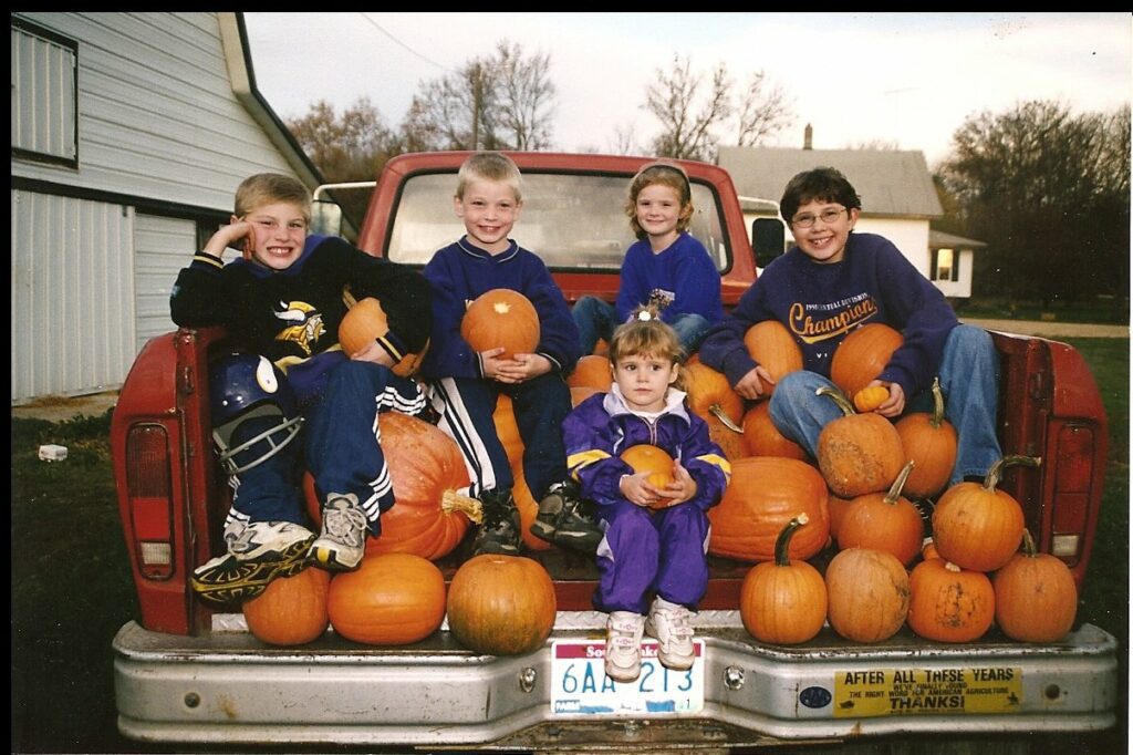 David and Dawnna Berndt's children in the bed of a truck with pumpkins 