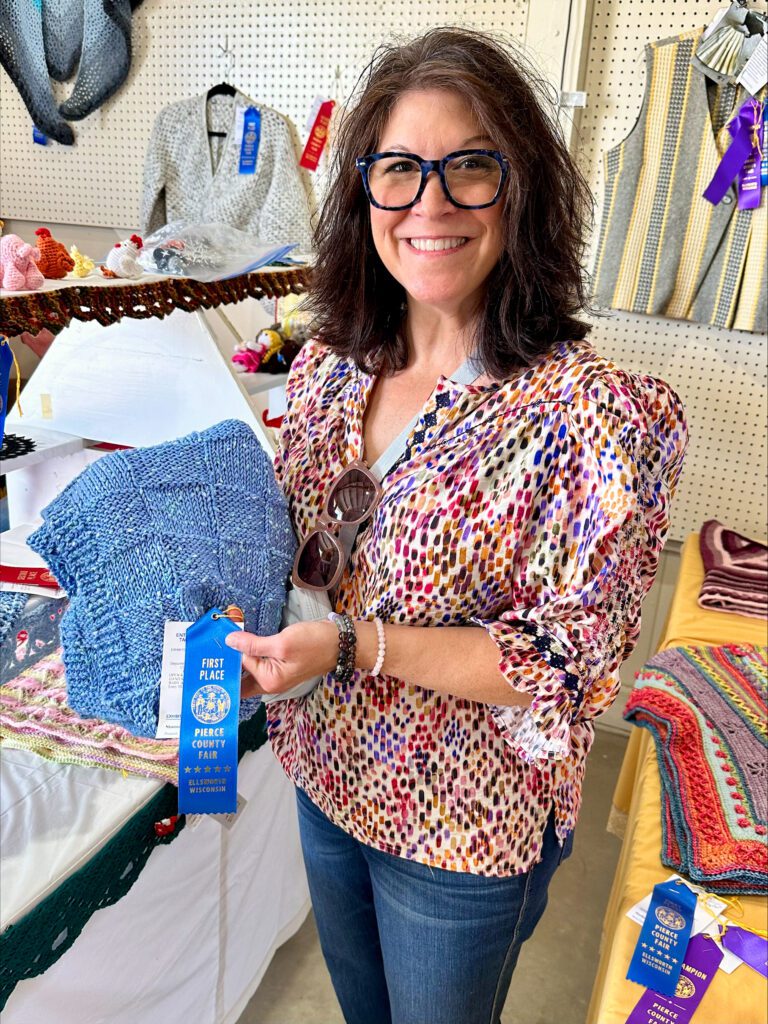 Shannon at the Pierce County Fair with blue ribbon and blue baby blanket