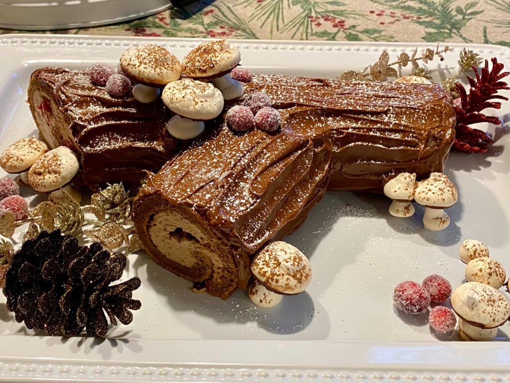 yule log on a white platter with festive decorations