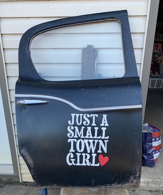 Just a small town girl written on an old car door at Homeless Treasures Tracy MN